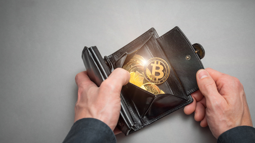 Opened wallet with a bitcoin in it ©Velishchuk Yevhen