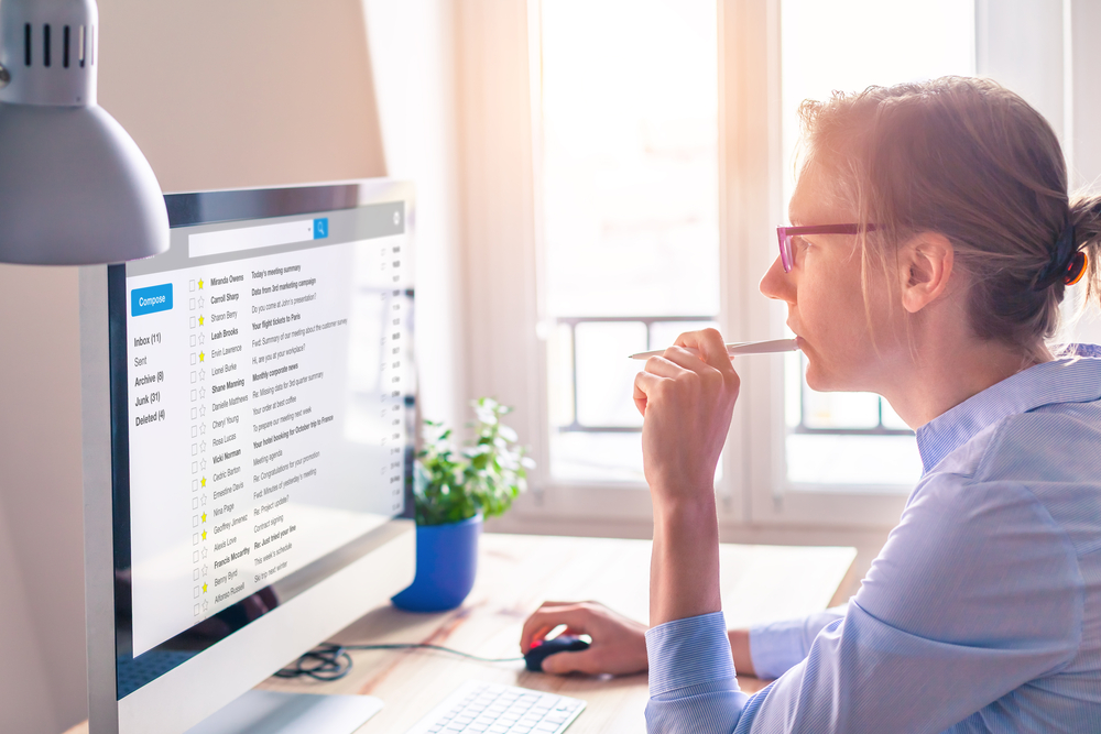 Female business person reading email on computer screen at work on internet ©NicoElNino